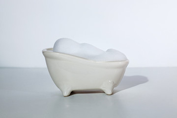 small white bathtub full of white airy bubble foam