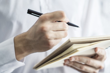 Man makes notes in a notepad. Closeup