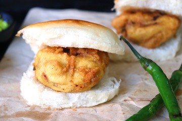Vada pav or wada pao is a vegetarian fast food dish native to the state of Maharashtra. Famous Mumbai street food served with green chutney and fried green chili. Copy space