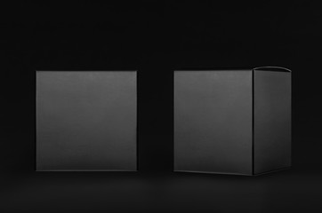 Luxury square black paper boxes side, front view on dark black background, mock up of packing, branding product, advertising, presentation, design.