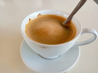 cup of coffee with spoon on white background