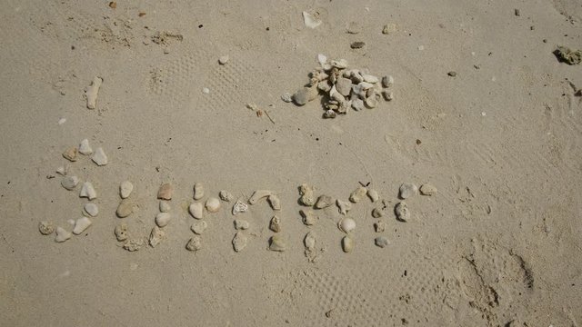 Hyperlapse, pebbling the word SUMMER on the sand
