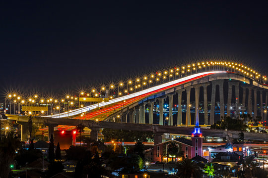 Long exposure of the curved and winding San Diego - Coronado Bridge at night.