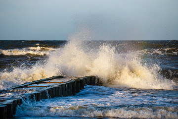 Autumn sea storm with splash from big waves over pier from the baltic coast
