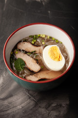 Composition with a bowl of rice noodles, meat and vegetables