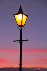 Fototapeta na wymiar Lamppost against colorful sky at dawn
