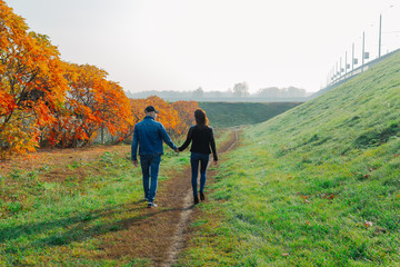 Obraz premium Loving couple walks in the autumn along the alley.