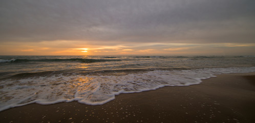 A calm and cloudy sunrise on the beach