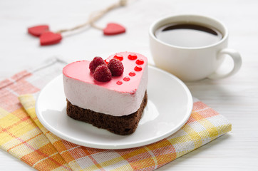 souffle cake in the form of heart  with cup of coffee on a wooden table