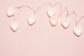 Heart shape garland on a pink pastel background. Valentine's Day or wedding party decoration