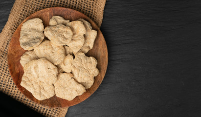 Raw Dehydrated Soy Meat or Soya Chunks on Black Stone Background