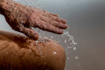 Fototapeta premium Falling water drops and human hand.