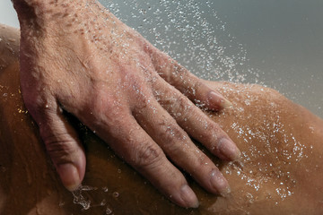 Fototapeta premium Falling water drops and human hand.