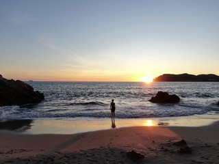Scenic view of a child  on the beach of Mallorca  against dramatic sky during sunset 