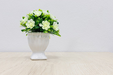 Decorative tree in flower pot on wooden table.