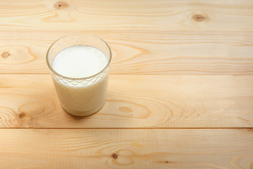 Obraz na płótnie Canvas Glass of milk on a wooden background