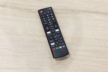 TV remote control on wooden table.