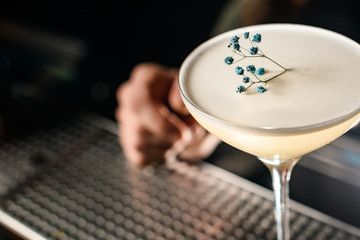 Creamy alcoholic cocktail in the glass decorated with a dried flower