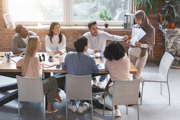 Young woman in hijab making business report, business meeting