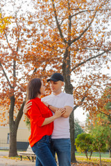 Fototapeta premium Happy couple in love on a background of yellow leaves in autumn.