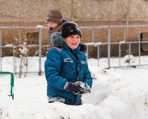 Fototapeta na wymiar children play snowballs in snow fort