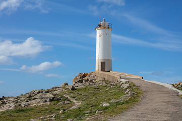 Fototapeta na wymiar Small and old lighthouse and blue sky