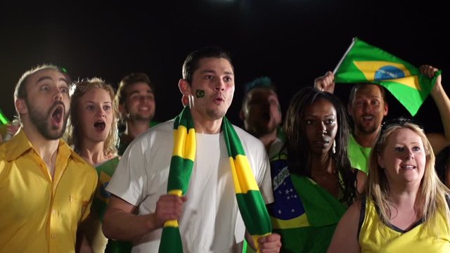 Football / Soccer fans or supporters Cheering a Goal at a match. Green and yellow. Brazil fans. Slow motion