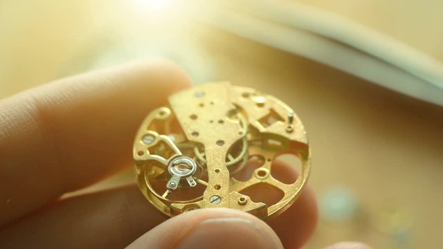 Mechanical watch repair, watchmaker installs cog wheel