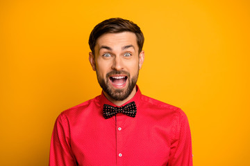 Fototapeta premium Wow. Photo of funny macho guy good mood friendly smiling enjoy unexpected surprise open mouth wear stylish red shirt with black bow tie isolated yellow color background