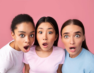 Three Surprised Girls Looking At Camera Posing On Pink Background