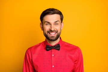 Photo of amazing funny macho guy good mood friendly beaming smiling show man wear stylish red shirt with dotted black bow tie isolated yellow color background