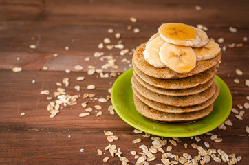 Breakfast oatmeal pancakes with banana and honey for a breakfast on wooden background closeup, ...