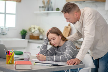 Obraz premium Short-haired man talking to his young sad daughter