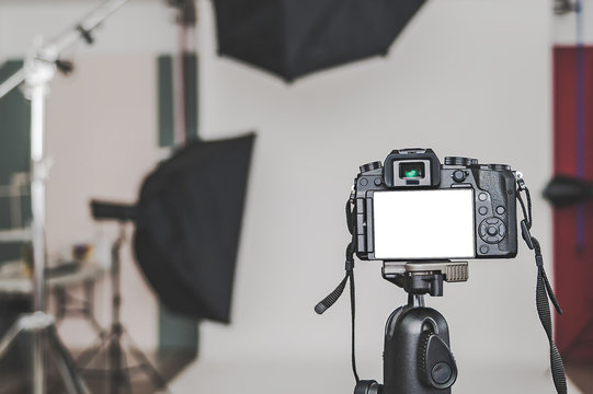 Mock up of a professional camera, in a photo studio, against the background of softbox light sources.
