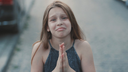 Cute teenage girl begging for favor. Close-up footage from above. Nice little lady looking at...