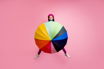 Full body photo of playful carefree girl jump close cover body blue turtleneck with colorful parasol enjoy fall free time isolated over pastel color background © deagreez