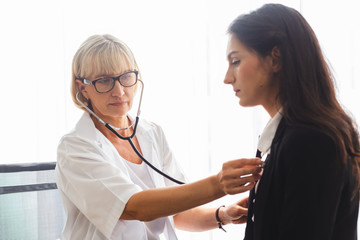 woman doctor using stethoscope examining patient, health and care concept.