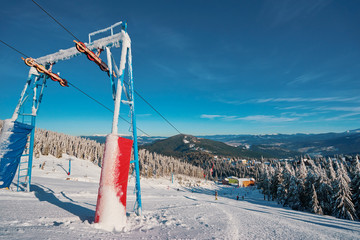 Ski lift with seats going over the mountain and paths from skies and snowboards.
