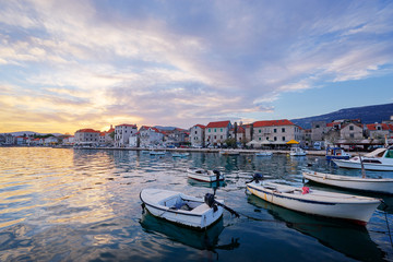 Beautiful sunset landscape. Fishing boat moored on Kastel coast in Dalmatia,Croatia.Old town near Adriatic sea.