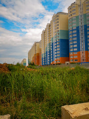 Multi-storey multi-family multi-colored houses and green reeds in the foreground