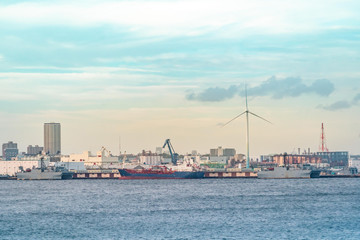 Obraz na płótnie Canvas Yokohama Industrial Port with transportation ship and windmill.