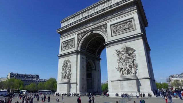 Arc de Triomphe in Paris, France. Driving past the famous Monument with many tourists
