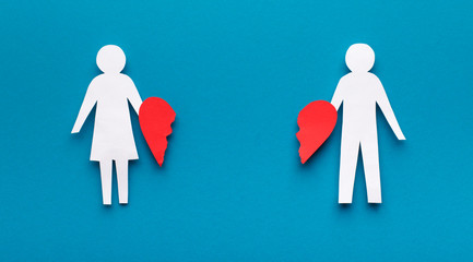 Papercut figures with broken heart on blue background