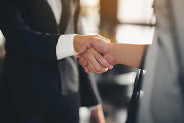 The hand of a businesswoman is shaking hands, check hands reached a business agreement.