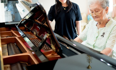 Senior elder woman plays piano