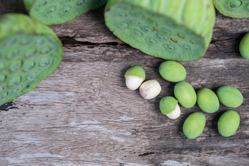 Lotus seed or lotus nut. The traditional Chinese and Indian medicine. Good for healty and can eat both fresh and dried seed as a snack or cooking as a food. Shooting on vintage wood surface table.