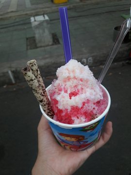 Cropped Hand Holding Ice Cream In Container