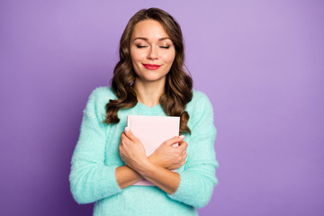 Photo of beautiful curly lady dreamer hold favorite love novel close to chest imagine herself main romance character eyes closed wear fuzzy pullover isolated pastel purple color background