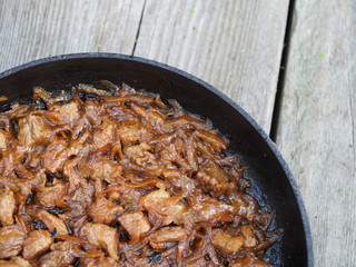 Beef goulash with vegetables and spoon, close up. Stewed meat in a frying pan.