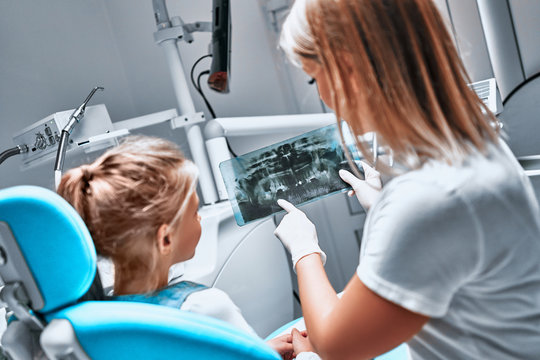 Orthodontic doctor examine with little girl x-ray image of teeth and gums